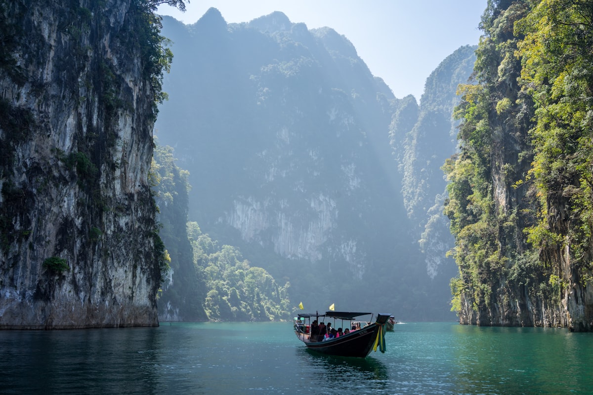 Longtailboot vor Kalksteinfelsen in Thailand